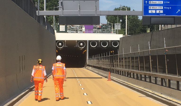 Two men in orange uniforms walking down a road
AI-generated content may be incorrect.